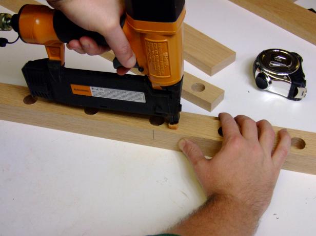 Now that your rails have been cut and drilled its time to attach them. Attach one support rail flush with the bottom edge and centered on one side rail. Attach using glue and #18 x 1-1/4-inch wire brads. Repeat to create a second side assembly with the remaining side rail and one support rail.