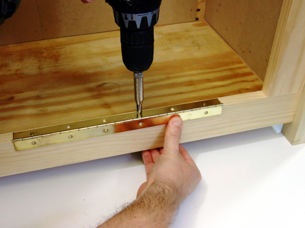 Position the continuous hinge centered on the top edge of the bottom side rail and attach using the included screws as shown in Image 2.