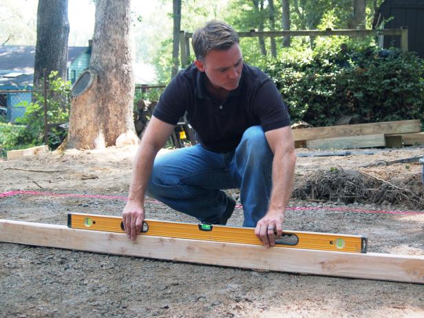 To make sure your area is level, place a long, straight 2X4 on edge across the area, then, place a three foot level on the board and adjust the gravel as necessary.