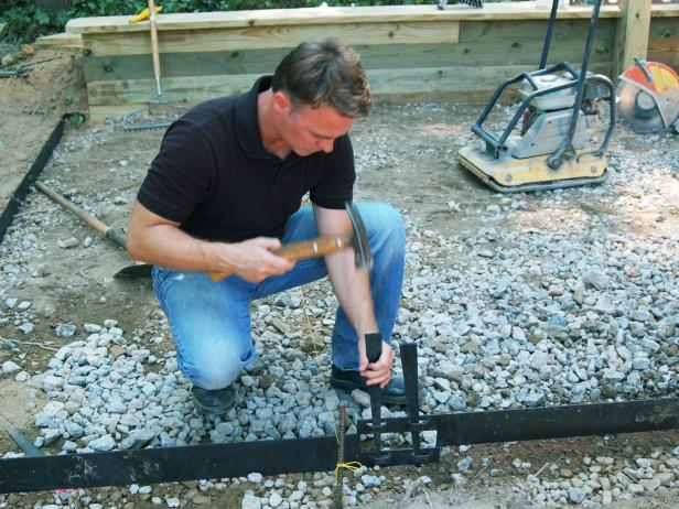 With the gravel base compacted, install galvanized steel edging around the perimeter of the base.