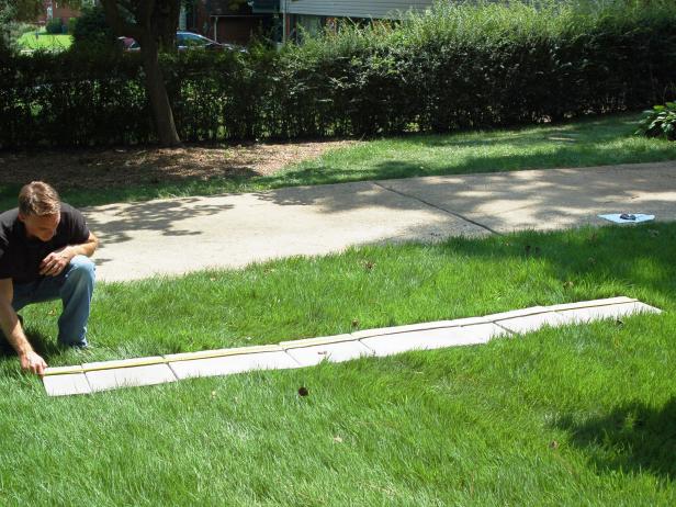 At your patio location, measure the area and pound four stakes into each corner. If desired, make sure you leave some space for edging.