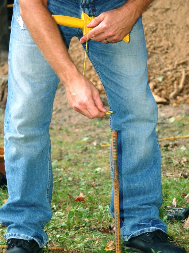 Place a stake at the corners of the area for the patio and tie mason string to mark off the area.