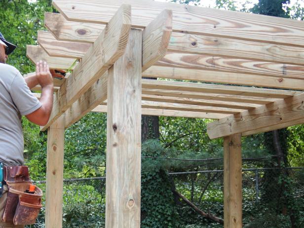 Take time to measure the overhang of each rafter carefully to keep the whole set in alignment. Install the rafters by fastening each in place with two 5-inch galvanized drive screws at each end.