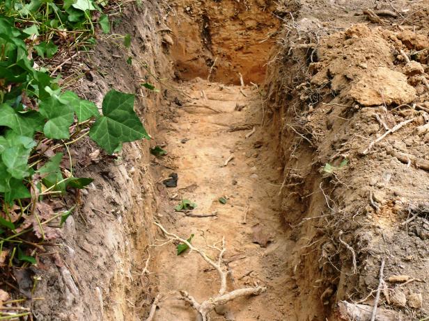 Make the trench about 8 inches deep. The base of the retaining wall should be half the wall's height.