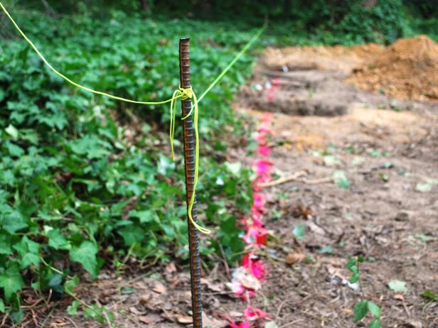 Connect the stakes with a string and adjust until it is level.