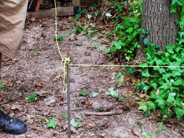 Before you can begin digging, add a guide string. This string follows the path you want your wall to follow. Place stakes at either end of the front edge of the wall.