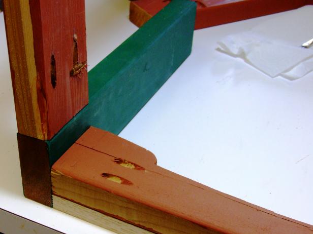 Place a scrap piece of 1-by material (3/4-inch thick) underneath the short front apron and positioned flush against two end apron assemblies and attach using glue and 2-1/2" pocket-hole screws.