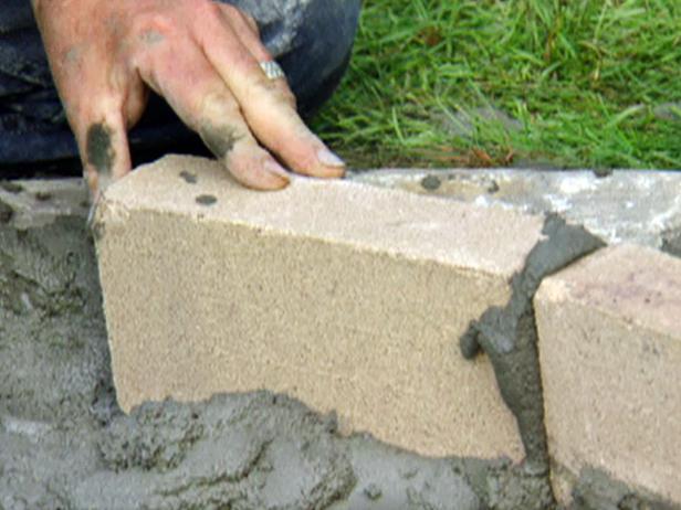 Fill the gaps in between bricks with wet mortar, scraping away any excess. Make sure to measure the inside and outside edges of the wall periodically to maintain the wall's thickness and circular shape.