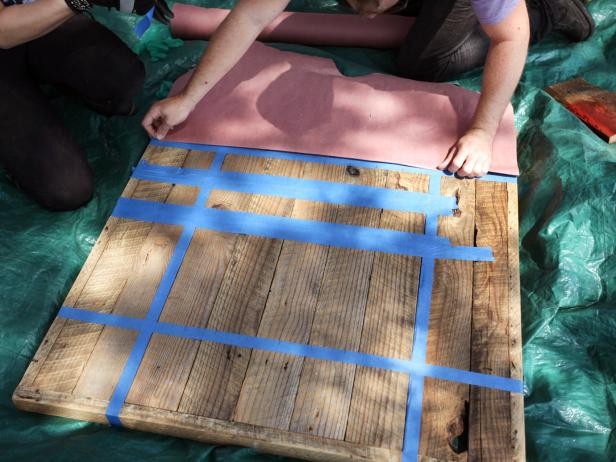 Using painter's tape and a tape measure, square the board in the center of the table. The size of the individual checkerboard squares depends on the size of the table. Use graph paper to sketch out the checkerboard square design.