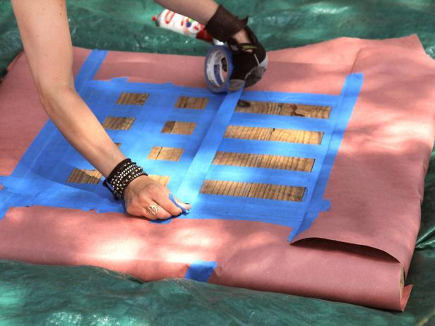 Cover the outside table surface of the checkerboard with paper. Continue to outline the checkerboard design with tape on the top of the old table surface.