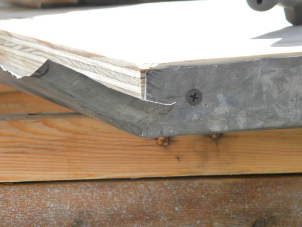Lay the metal-wrapped top on the bar legs. Use old nails or screws to attach the top in place.