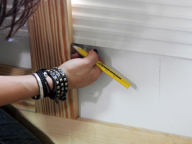 To cut a stile under the window, place a shortened length of stile atop the baseboard. Mark the stile where the cut will be made to fit the window trim. When cutting stiles around wall receptacles, use the pencil to outline the cut locations on the wall, then transfer the cut lines onto the stile.