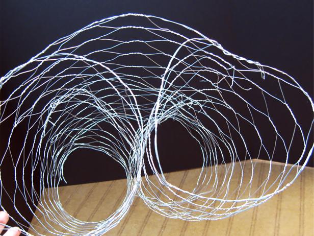 Roll a four-foot length of 2-inch cell chicken wire into two cylinder shapes. Twist the cell ends to the back to hold shape. Create two of these so you'll have four cylinders.