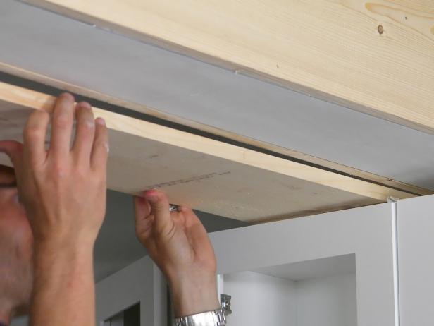 If wall cabs are still in place, carefully guide the glue-covered bottom cut into place, sliding it between the wall cab and the bottom of the girder.