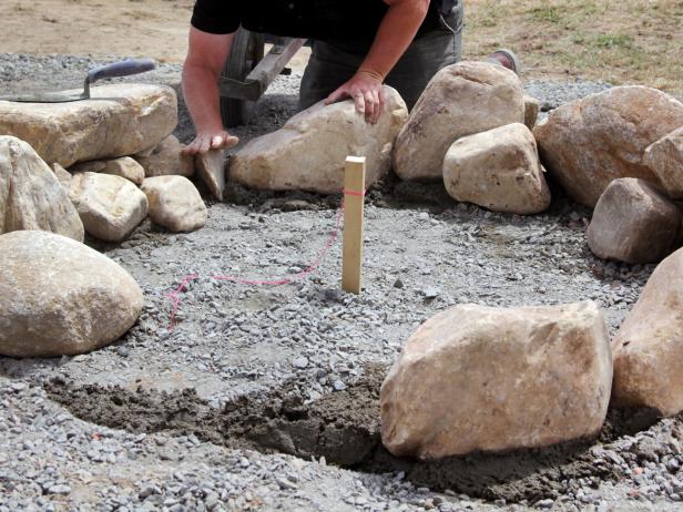 After you have placed the larger stones around the perimeter of your fire pit, fill in the gaps with smaller stones to complete the ring around your pit.