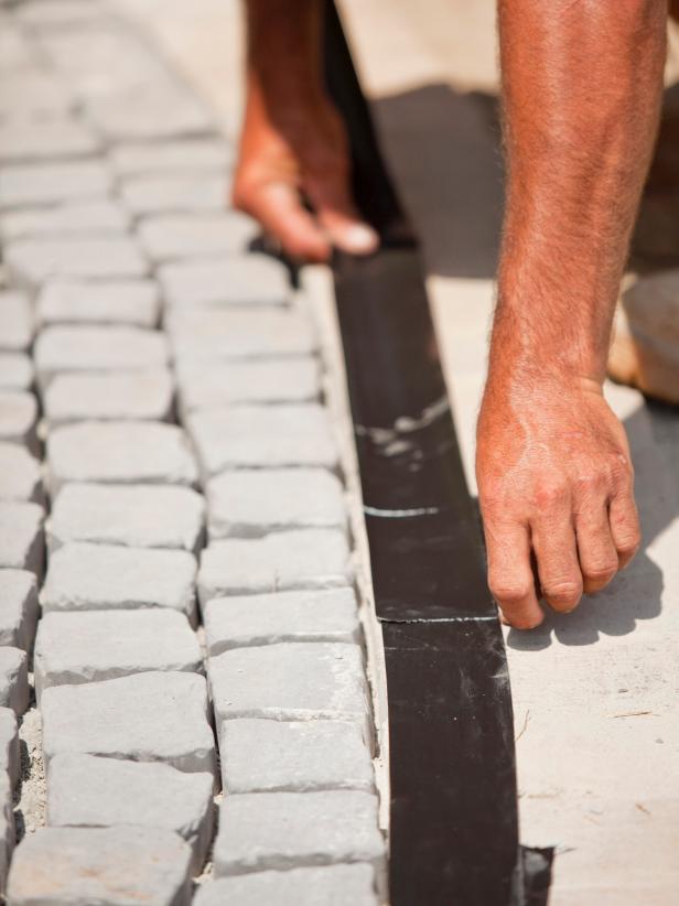 Tape the edges of your walkway so as to keep the bricks free of epoxy.