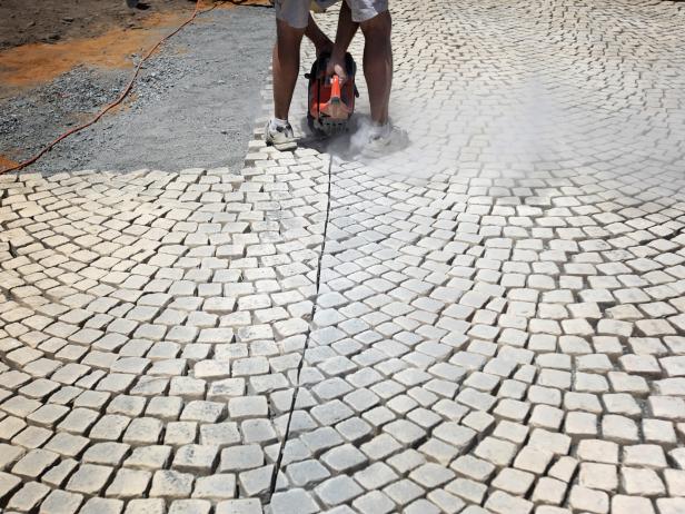 After tracing your cutoff line, use a concrete cut-off saw to cut the edges of your stone patio. Be sure to wear the appropriate protective gear to prevent injury.