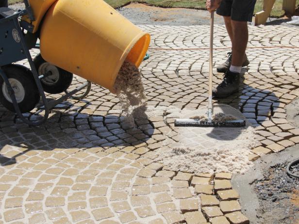 Empty the mixed grout onto the stones and squeegee the sand and epoxy grout mixture around to cover the joints between the stones.