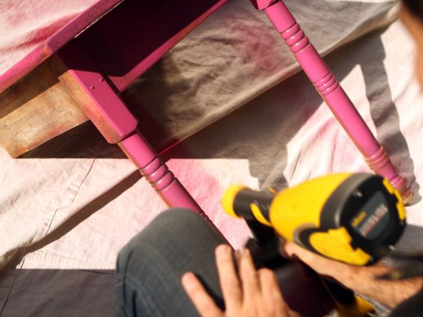 Pour porch and deck paint into paint container portion of paint sprayer. Attach container to sprayer and apply an even base coat to table, keeping about eight inches' distance between table and sprayer to avoid paint buildup and dripping. Allow at least one hour for base coat to dry then apply a final coat.