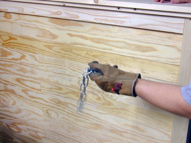 There are many methods for distressing lumber to give it an aged and "well-loved" appearance. Use a scrap length of chain to add dents and nicks.