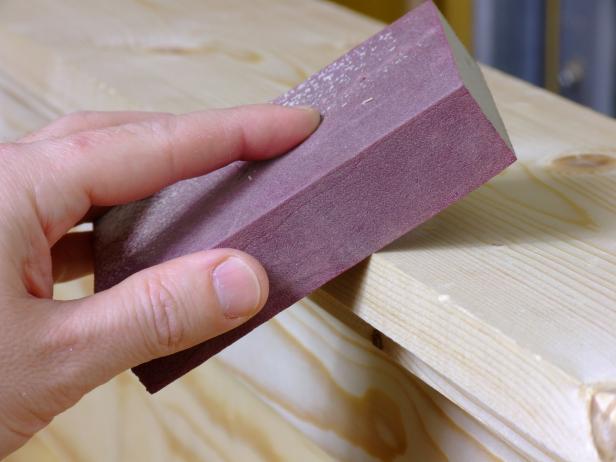 Wear down random spots of wood using a sander.
