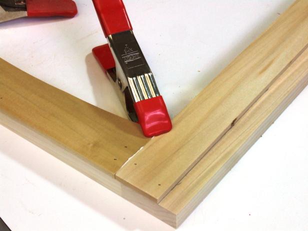 Position the door rail trim flush with the outer edges of the door rails (with the curved area facing in) and attach using glue and 5/8-inch brads. Be sure to apply glue to the ends of the door rail trim and clamp the part in place with the door stile trim until the glue sets.