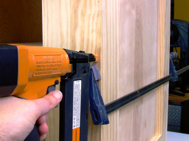 Position the shelves on the shelf supports, beginning with the bottom shelf, with the shelf nosing flush against the front edge of the shelf supports, and attach to the supports using glue and 1-1/2-inch brads.