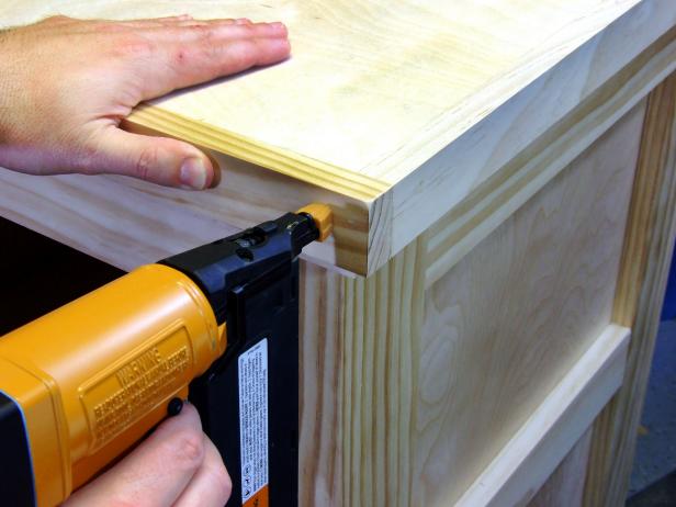 Position the two remaining top trim parts flush with the top edge of the top and the ends of the first two top trim parts, and attach using glue and 1-1/2-inch brads.