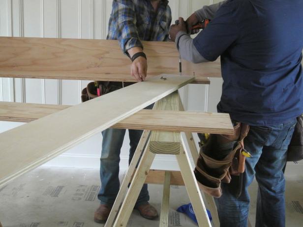 Start assembling the four pieces. Wood glue and screws will be used to secure the panels together at the corners. Drill three pilot holes in each end of the side panels and start the screws on the flat surface, then assemble the four pieces on the floor (12 screws total). Make sure that each piece is flush to the next. Once these four pieces are joined, the four gussets will be installed flush to the bottom of each frame corner. Again use glue and three wood screws on each side (24 screws total) making sure that the screw heads are flush or slightly recessed*.*DIY Tip: Before installing the gussets, make sure the frame is square by checking the diagonal measurements. If the frame is square, both measurements will be equal.