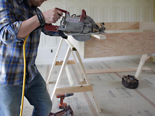 Install the two plywood ledger strips even with the bottom of the bed frame sides. Use wood glue and install 1-1/4" screws 6" on center through the face of the ledger into the side panel.