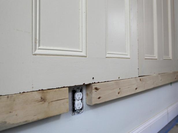 Working from the center out, stand doors on the flat, solid surface and secure them at tops and bottoms with 3" screws into studs.