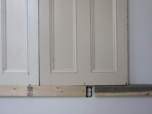 Working from the center out, stand doors on this flat solid surface and secure them at tops and bottoms with 3" screws into studs.