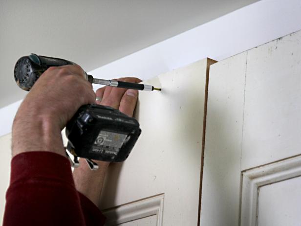 Working from the center out, stand doors on this flat solid surface and secure them at tops and bottoms with 3" screws into studs.