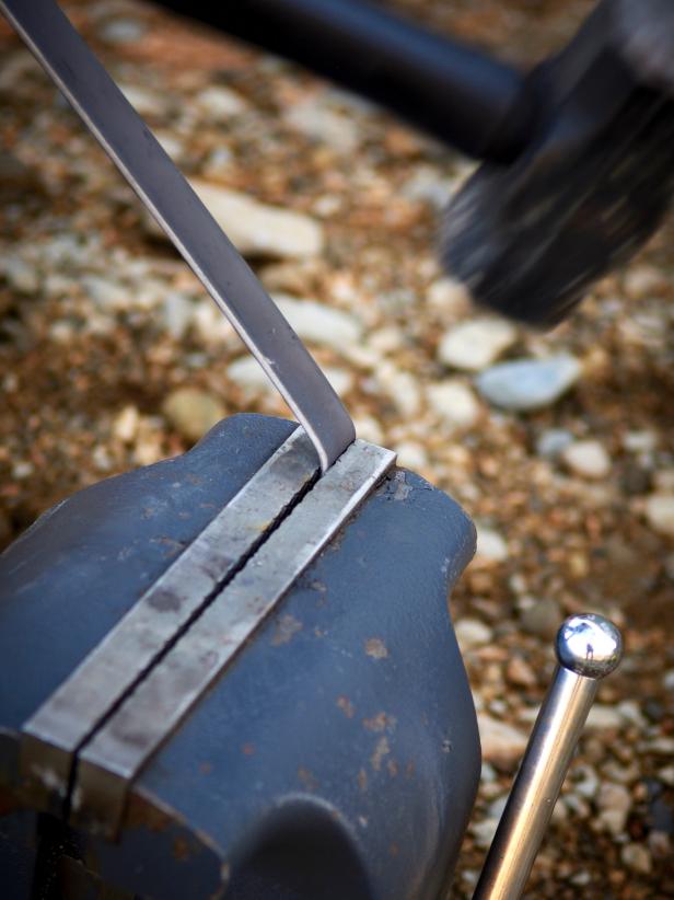 Clamp securely into a vice with the mark approximately 1/16" above the vice jaws. Pulling slightly on the top of the strap, tap the strap near the vice jaw with the sledgehammer until a 90-degree bend is formed.