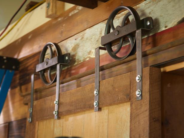 Drill two holes in each strap (8 total) to 1/2" for the 5/16" lag bolts. Level the wheels and bolt the straps to the door.