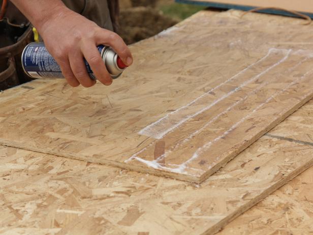Spray glue onto board in overlapping rows of adhesive on the piece of sheathing.