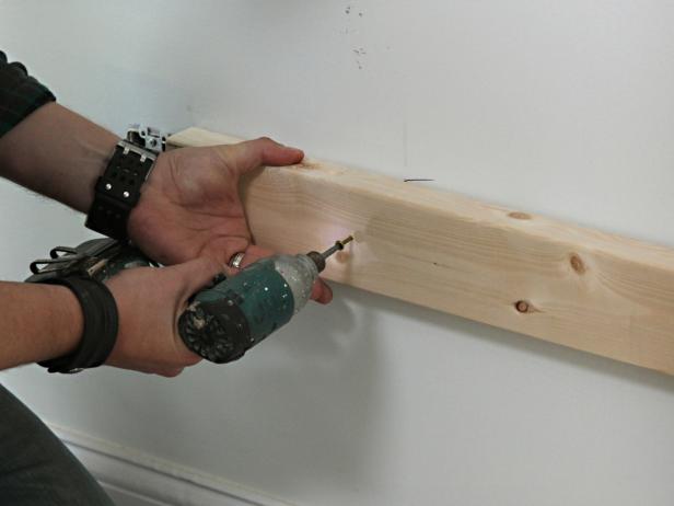 Mount 2x4 ledgers along the wall with 3" wood screws driven into studs.