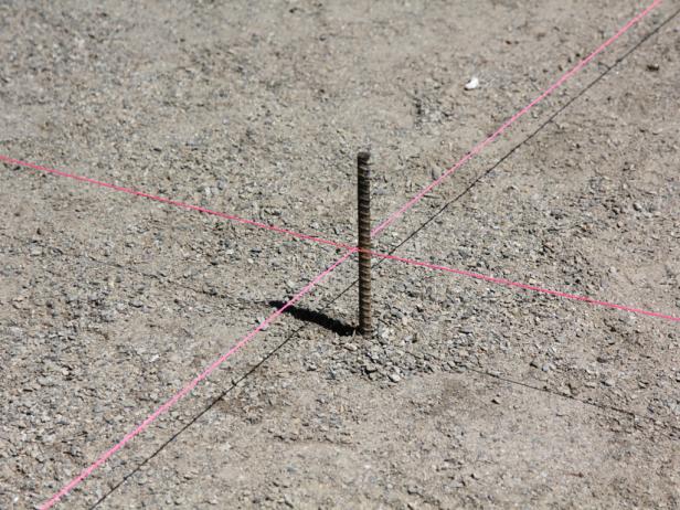 Establish the center point in your project area by marking north, south, east and west. Drive four grade stakes plumb at the outer perimeter, and use mason's string for guidance between these opposing points.