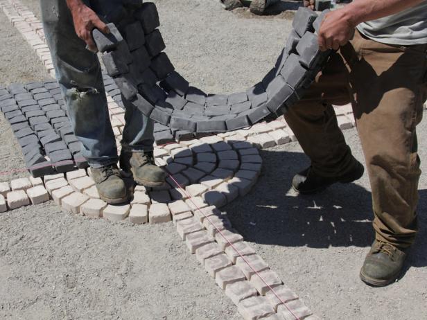 Install cobblestone patio. With full straight mats, start infilling from the center point out along each side of one radial arm.