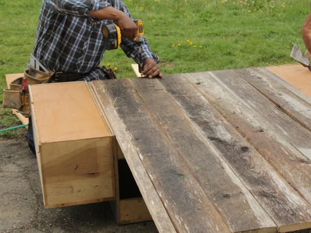 After attaching the center board to the back of the cabinets, the remaining boards should be laid out and attached so they are flush at each end of the outer cabinets.