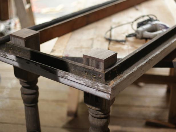 Carefully trace the leg tops on the bottom side of the planks and then flip it over onto a work surface. Drill a 1/2” hole with each square mark near the line but not touching it. Using a jigsaw, carefully cut out each square.