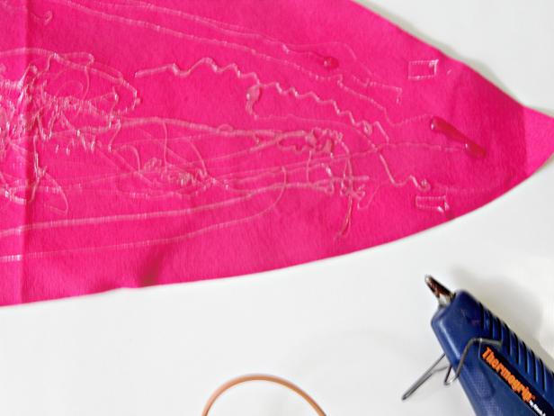 Using a Hot Glue gun attach feather to fabric