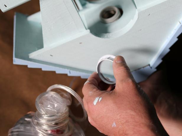 Thread the cord of the pendant kit through up inside of the birdhouse and through the hole in the roof.