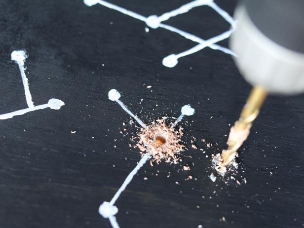 Attach 1/4â drill bit and add holes directly through the painted dots (stars).