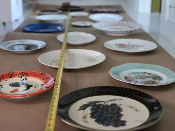 Based on the dimensions of the wall space, arrange the plates on an unfurled roll of craft paper, moving them around randomly until the proper shape forms.