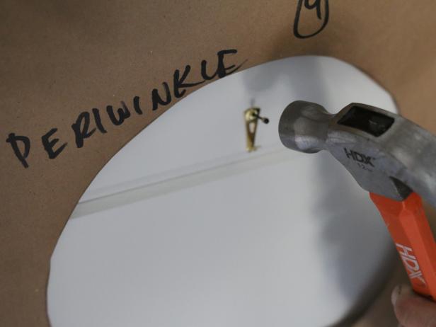 Use a hammer to attach the plate hanger nail.