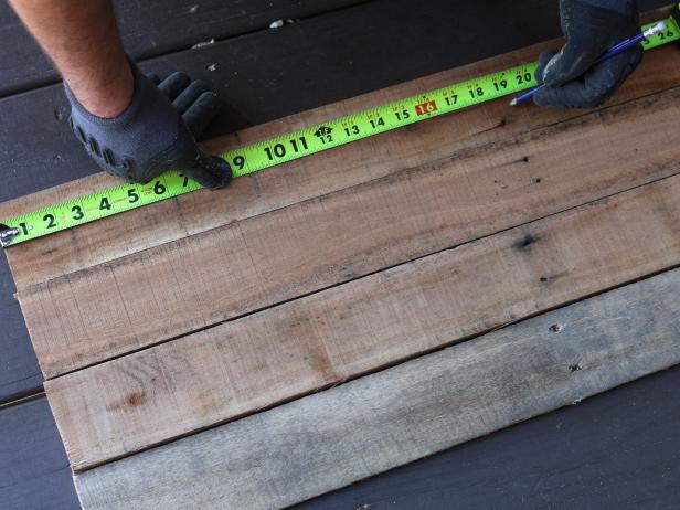 With the planks cut from the pallet, measure and mark them to the desired height and width for your entryway using measuring tape and pencil.