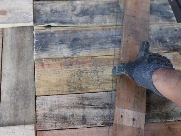 The side panels will be cut at 45 degree angle. This gives the storage box a geometric wedge-like shape. Use a straight edge or another plank of wood to create a perfect line across the planks, then mark using the pencil.