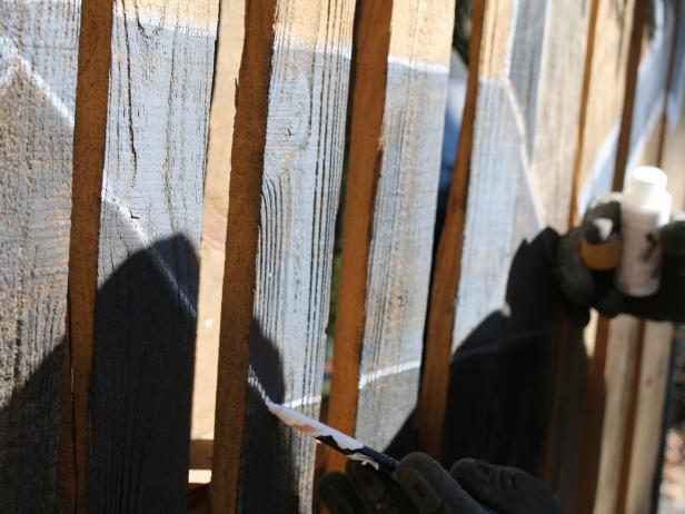 Depending on your level of painting skills, either trace a stencil to the surface of the wooden pallet planks with a pencil or free-hand your design with the paint and a paint brush.
