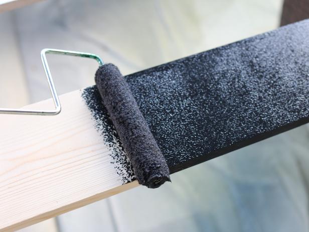 Before the 1x5â pressure-treated trim is cut to size, paint all four sides of it with the semi-gloss latex using the paint roller.